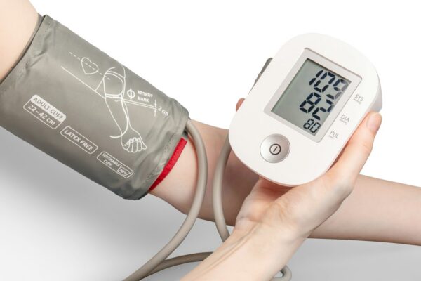 Tensimeter digital dengan manset abu-abu dipakai untuk memantau tekanan darah lansia di rumah